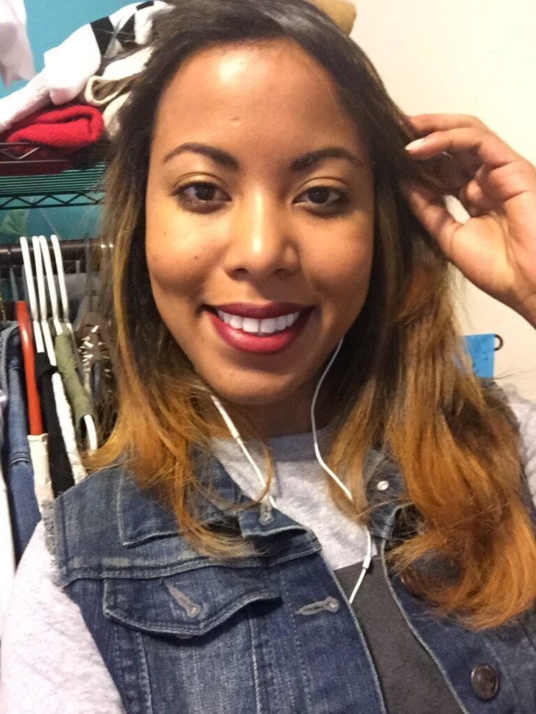 Woman smiling with straightened hair and ombre blonde ends, appearing healthy