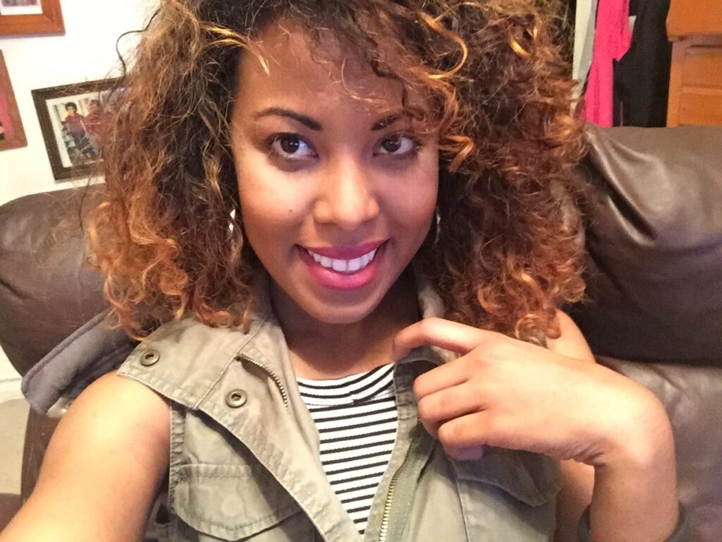 Close-up selfie showing curly hair with uneven texture and visible dye damage