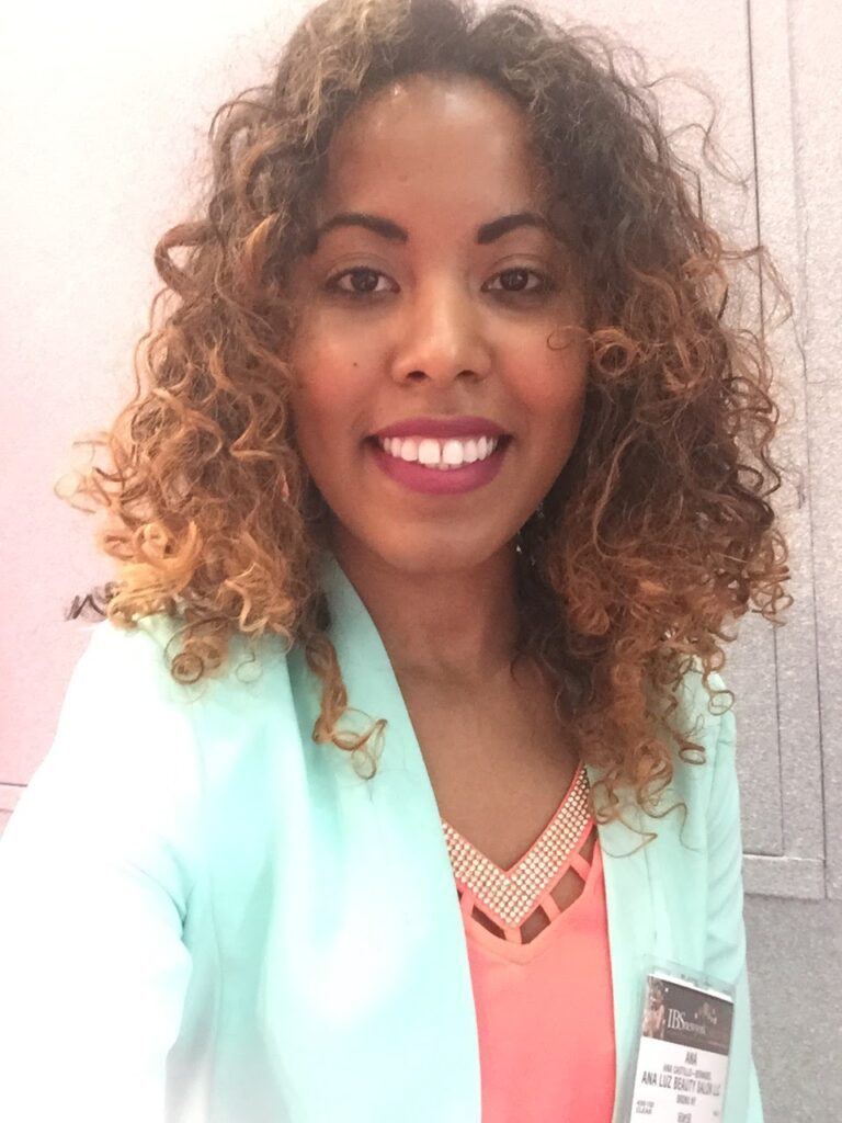 Smiling woman with highlighted curls, showing frizz and partial curl pattern loss