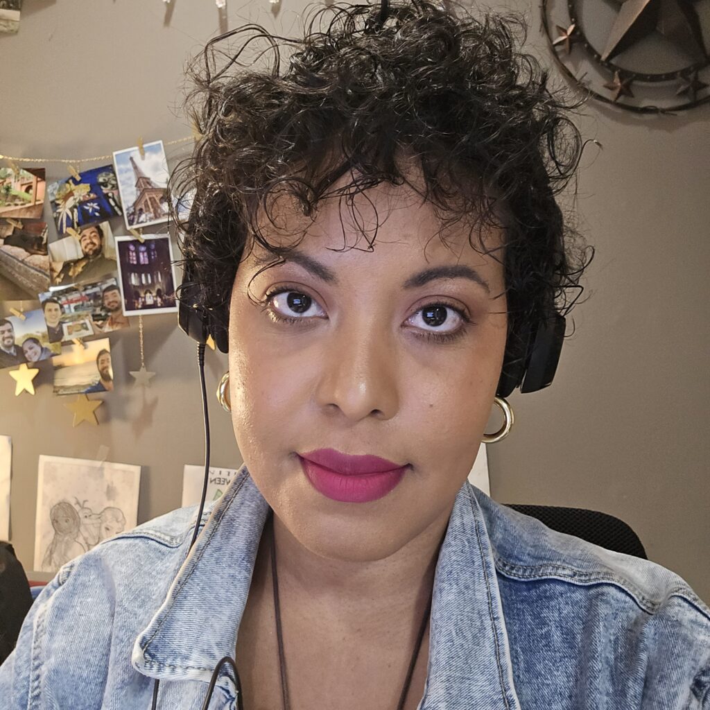Woman wearing Pink lipstick and a white shirt, showcasing her go-to short curly style.
