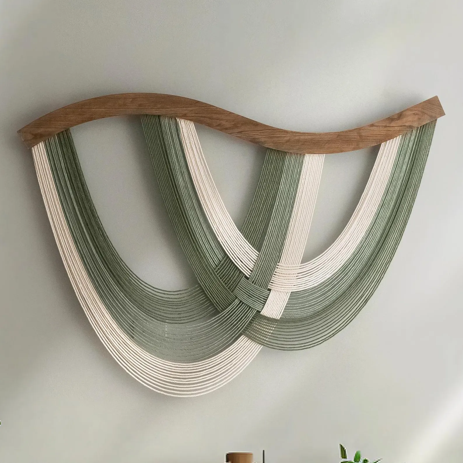 Handmade macrame fiber wall hanging in off-white, styled against a light wall with neutral-toned furniture. Soft, tactile, and perfect for a child-safe space.