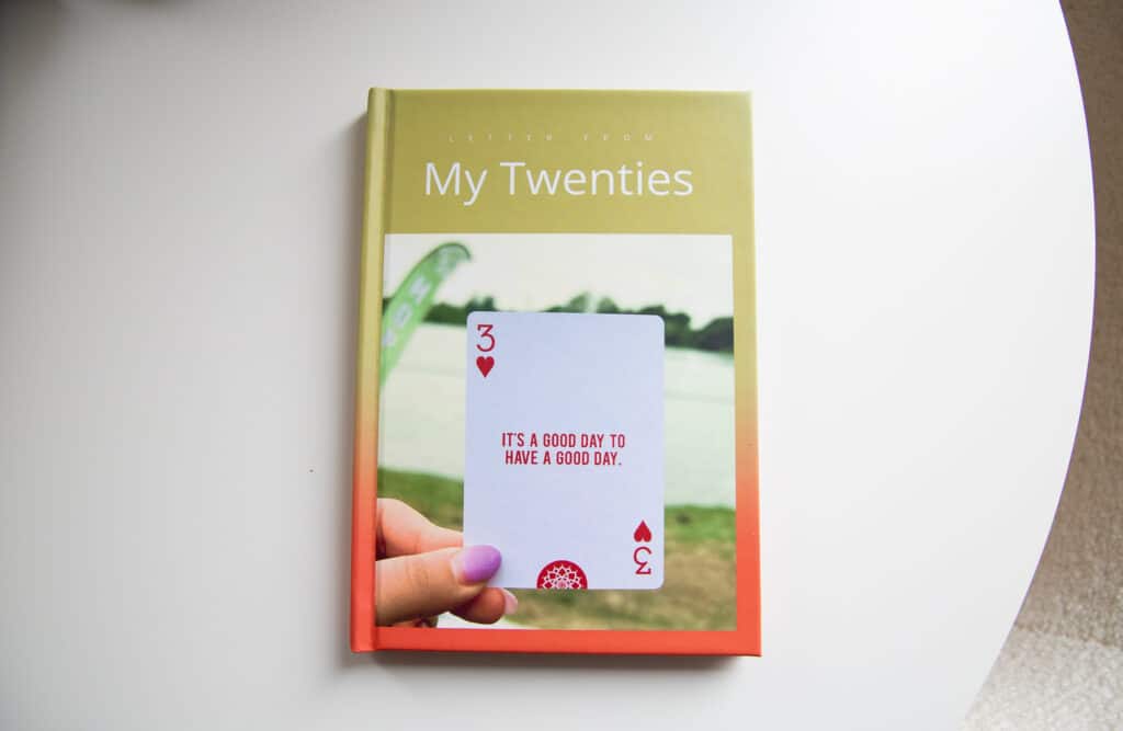Printed Kinnect memory book titled “My Twenties” with a playing card on the cover that says ‘It’s a good day to have a good day’.