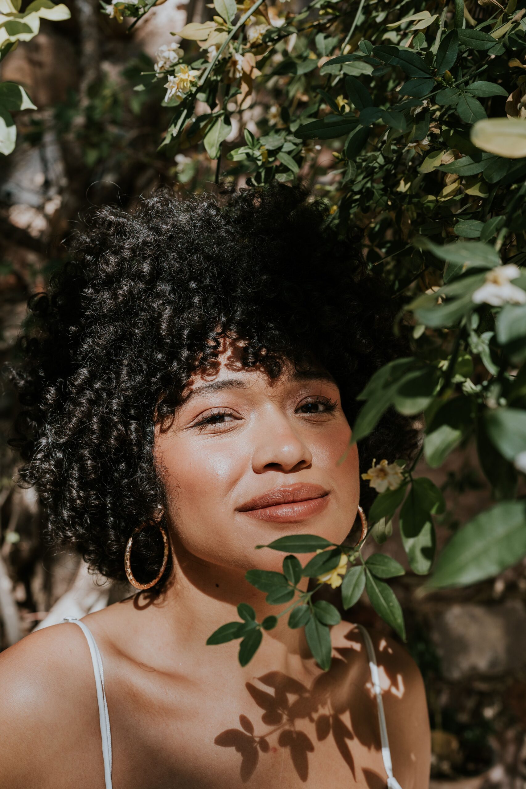 Woman with tightly curled natural hair outdoors, illustrating curly hair texture and curl pattern.