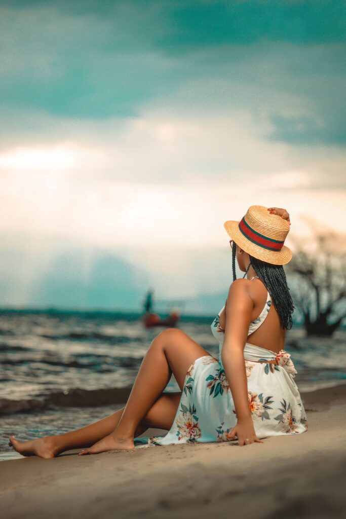 Woman wearing a wide-brim hat while relaxing at the beach to help protect her scalp from the sun.