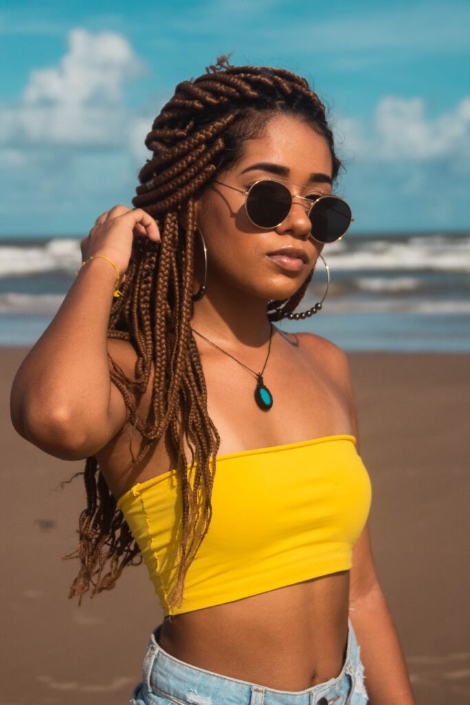 Woman wearing long braids at the beach to help keep her hair protected from wind and tangles.