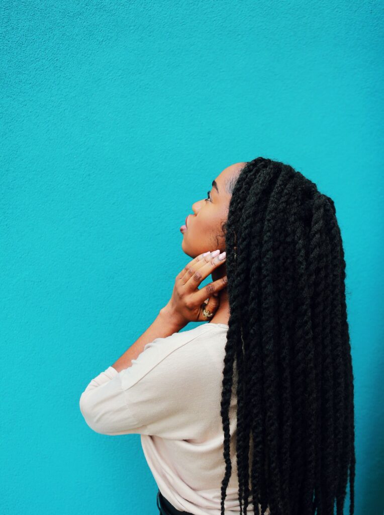 Woman wearing long two-strand twists, an example of a protective hairstyle for natural hair.