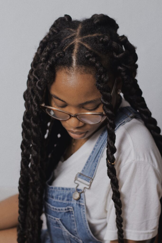 Person wearing chunky two-strand twists, a protective hairstyle that requires regular maintenance.